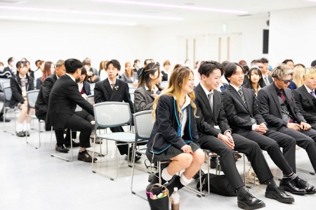 卒業式はスーツ、制服、私服など、皆さん自由なスタイルで参加します。おしゃれで楽しそうな笑顔があふれています！